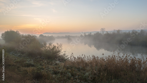 Sunrise over the hills with fog over a river