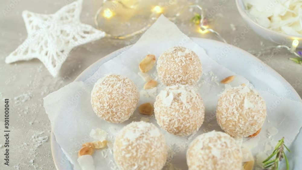 Homemade candies with coconut roasted almonds on a Christmas season table decorated with lights and stars. Homemade candies with coconut roasted almonds on a Christmas season table decorated with lights and stars.