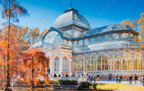 Crystal Palace in Retiro Park in Madrid autumn colorful view with people, trees, plants and environment