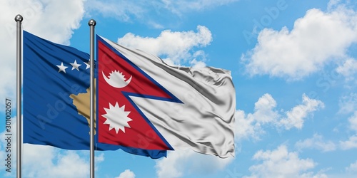 Kosovo and Nepal flag waving in the wind against white cloudy blue sky together. Diplomacy concept, international relations.