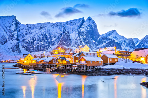 Sakrisoy village on Lofoten Islands in Norway, beautiful twilight view with street lamp reflections during winter season. Blue color in nature. photo