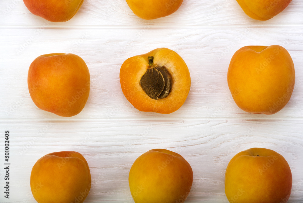 Apricots. Ripe fresh apricots on a wooden white background, top view.