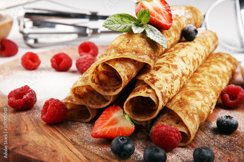 Delicious Tasty Homemade crepes or pancakes with raspberries and mint on rustic background