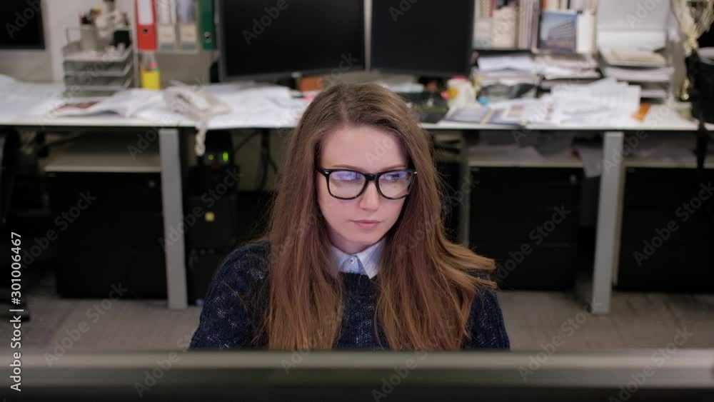 Young woman architect in the office checks the results of work Young woman architect in the office checks the results of work