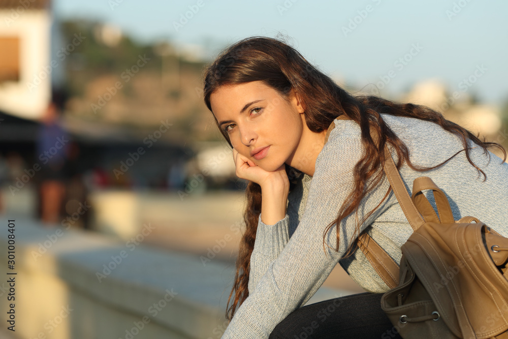 Fototapeta premium Serious girl looks at you at sunset in the street