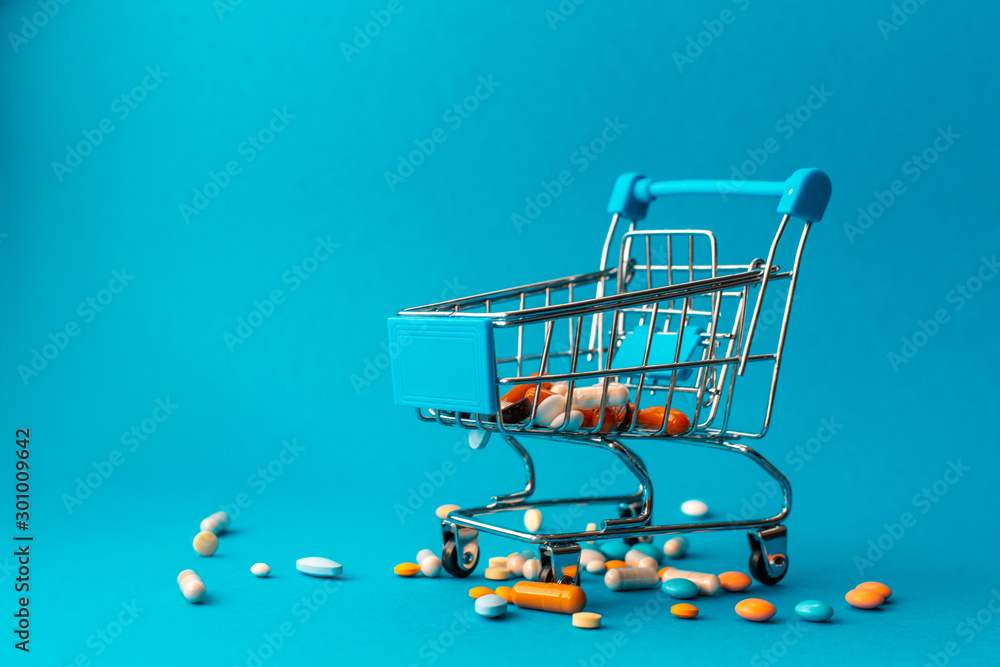 Cart from the supermarket filled with colored pills. Medical concept. Shopping at the pharmacy.