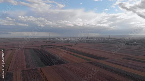 Oil rafinery in the middle of the agriculture fields. Health concept with food production and oil rafinery pollution.