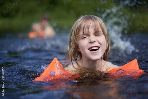 The girl swims against the background of bathing other family members.