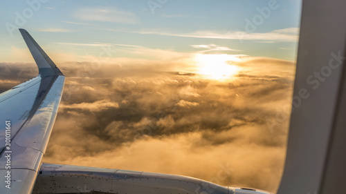 views from the window of an airplane above the clouds at sunset