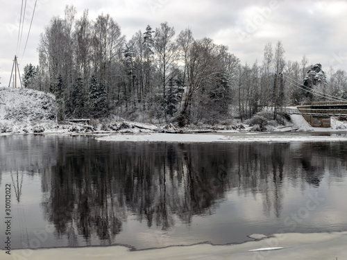 landscape with snow-covered trees on the banks of the river