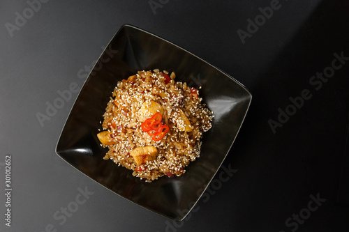 Obraz na płótnie Asian fried rice with eggs, pineapple and sesame close-up on a plate, horizontal view from above. Nigerian food party: Jollof rice with fried chicken close-up on a plate. w salonie