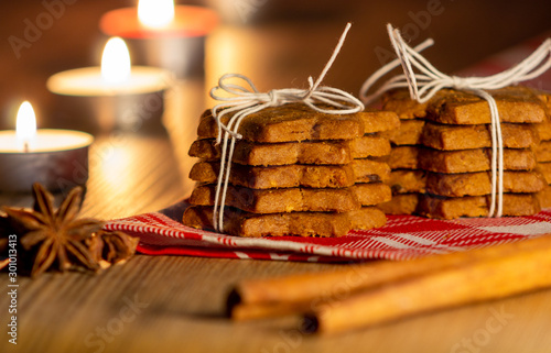 pila di biscotti legati con spago, cannella, chiodi di garofano e candele accese photo