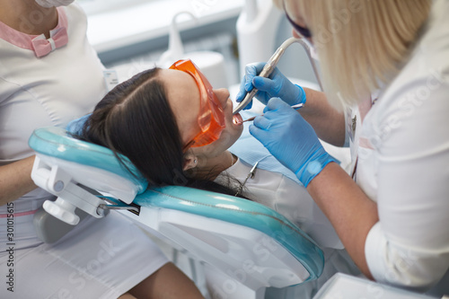 Doctor dentist treats teeth of a beautiful young girl patient. The girl on reception at the dentist. Doctor dentist treats tooth