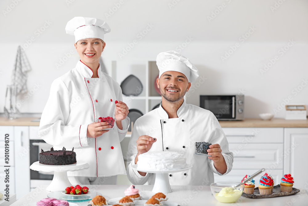 Young confectioners cooking tasty dessert in kitchen Young confectioners cooking tasty dessert in kitchen