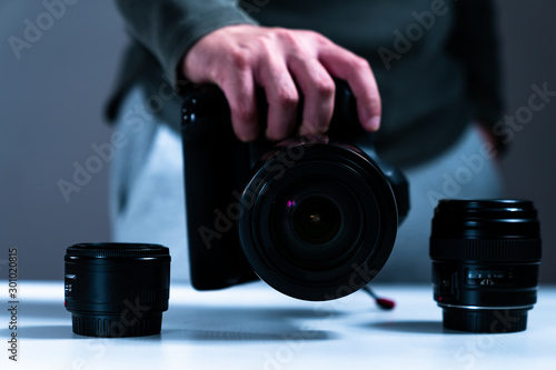 photographer equipment, cameras, lenses and hand reaching out to them