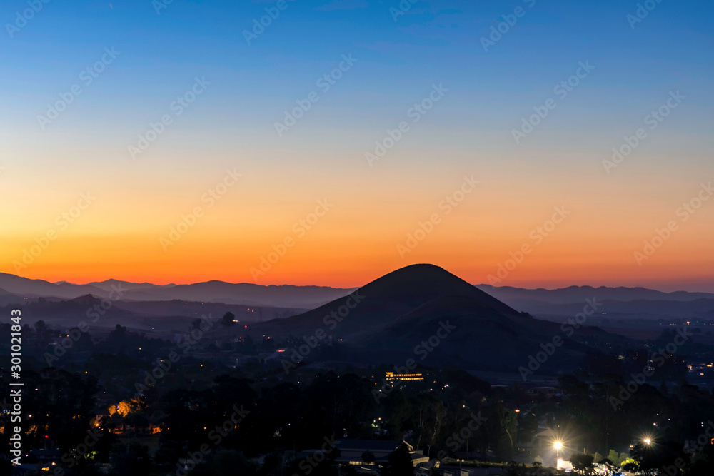 Mountain Silhouetted at Sunrise with City