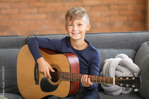 Little boy playing guitar a...