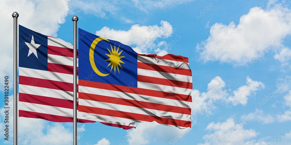 Liberia and Malaysia flag waving in the wind against white cloudy blue sky together. Diplomacy concept, international relations.