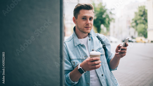 Cool man with coffee and phone on street
