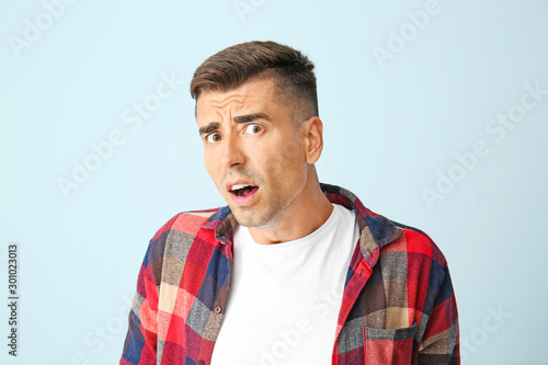 Shocked young man on color ...