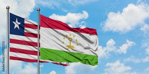 Liberia and Tajikistan flag waving in the wind against white cloudy blue sky together. Diplomacy concept, international relations.
