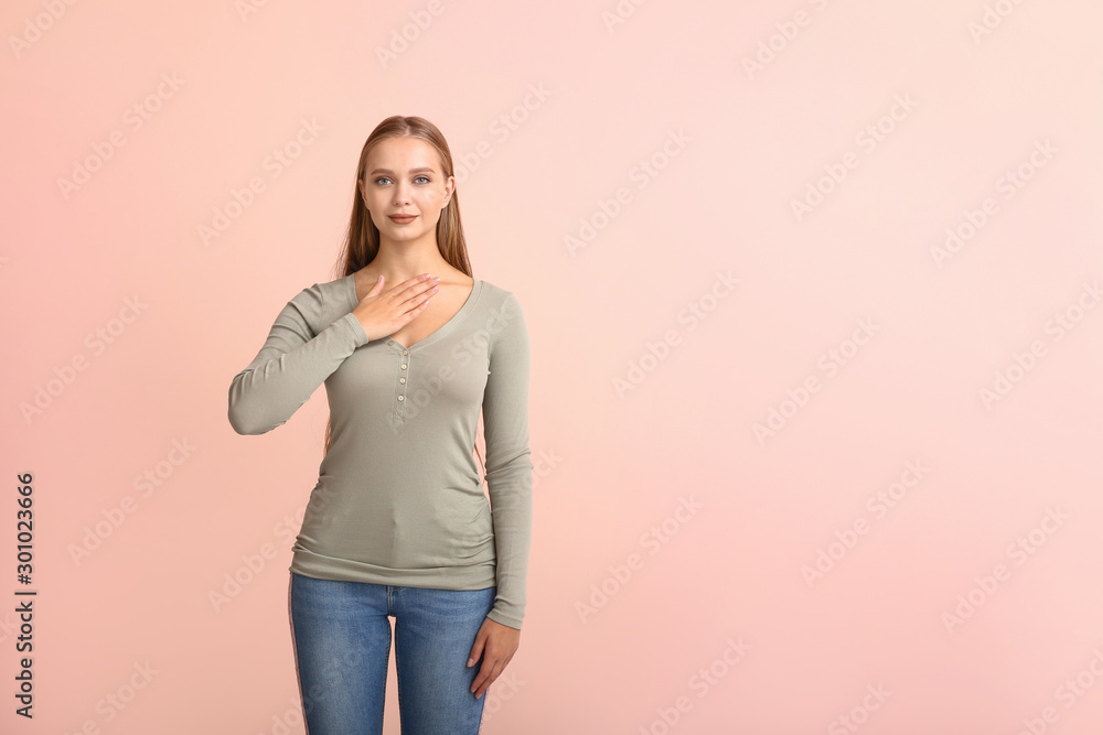 Young deaf mute woman using sign language on color background Young deaf mute woman using sign language on color background