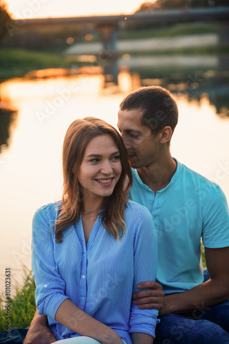 A couple in love on the shore of the lake.Couple at sunset by the river