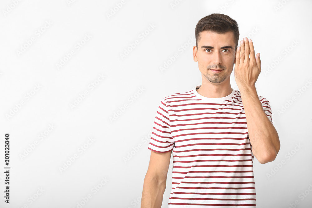 Young deaf mute man using sign language on white background Young deaf mute man using sign language on white background