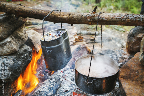 Bonfire cooking during trekking trip in mountains, location Lucian way near Kemer city in Turkey, Mediterranean. Kettles over camp fire during bivouac. Tourist lifestyle, Wanderlust concept.