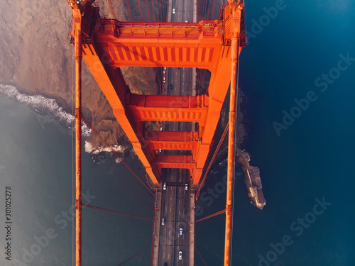 Aerial top view of Golden Gate Bridge with highway, metropolitan transportation  infrastructure, birds eye view of automobiles and car vehicles moving on road of suspension construction
