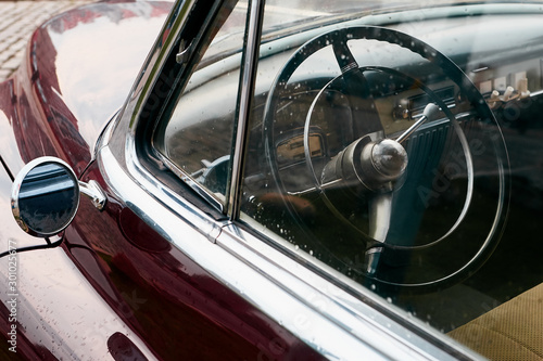  Interior of a retro car through the glass in raindrops. Soft focus.