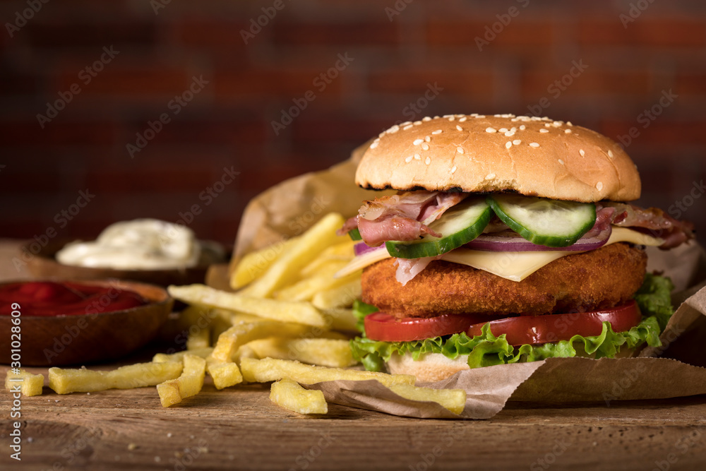 Fresh burger on wooden table and brick wall background
