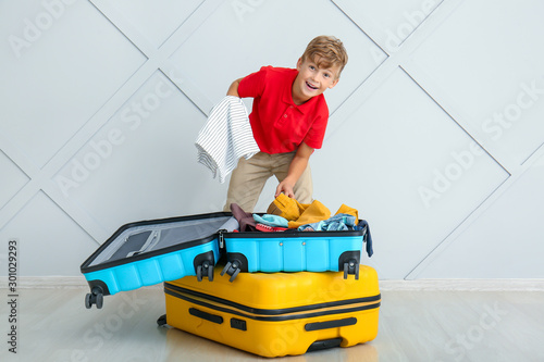 Cute little boy packing sui...
