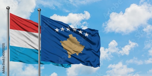 Luxembourg and Kosovo flag waving in the wind against white cloudy blue sky together. Diplomacy concept, international relations.