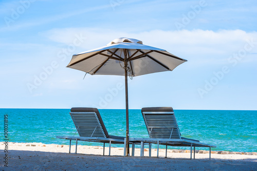 Fototapeta Naklejka Na Ścianę i Meble -  Beautiful umbrella and chair around beach sea ocean with blue sky for travel