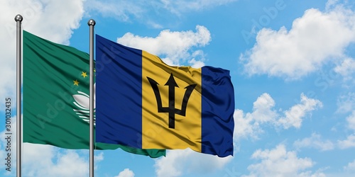 Macao and Barbados flag waving in the wind against white cloudy blue sky together. Diplomacy concept, international relations.