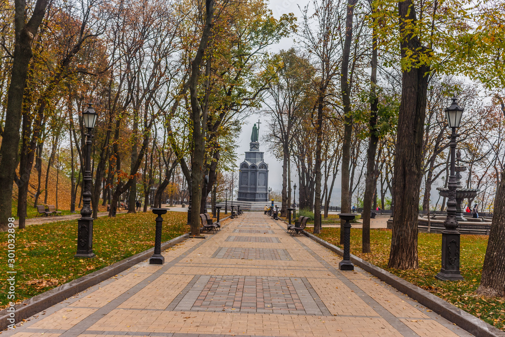 Obraz premium KIEV, UKRAINE - Oktober 27 2019: Autumn in Kiev park. Saint Vladimir Monument view through yellow tree foliage in Vladimir park and view of Dnieper River in urban park Volodymyrska Hill
