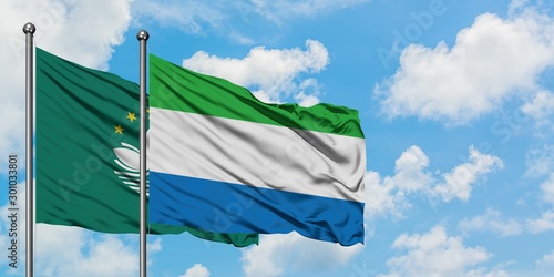 Macao and Sierra Leone flag waving in the wind against white cloudy blue sky together. Diplomacy concept, international relations.