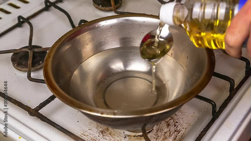 cook semolina or cereals adding vegetable oil with a spoon on a gas stove in a plate a soucepan in water whit steam 4k with sound cook semolina or cereals adding vegetable oil with a spoon on a gas stove in a plate a soucepan in water whit steam 4k with sound