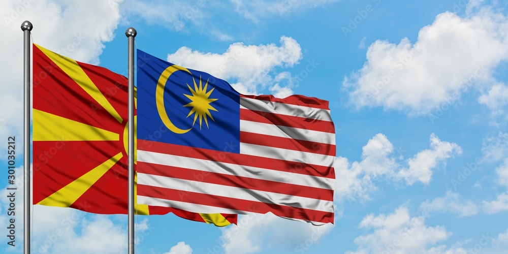 Macedonia and Malaysia flag waving in the wind against white cloudy blue sky together. Diplomacy concept, international relations.