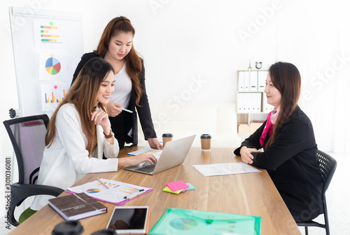 asian female officer teaching about organization business profits to her teams with laptop, they discussion about performance and result, innovation and development, happiness workplace