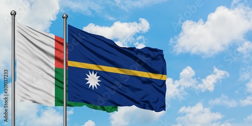 Madagascar and Nauru flag waving in the wind against white cloudy blue sky together. Diplomacy concept, international relations.