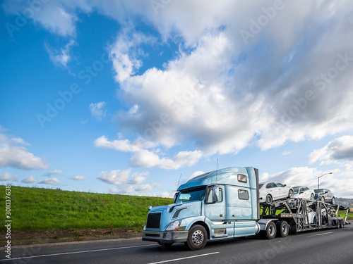 Картината върху платно Big rig car hauler semi truck transporting cars on the special semi trailer driv