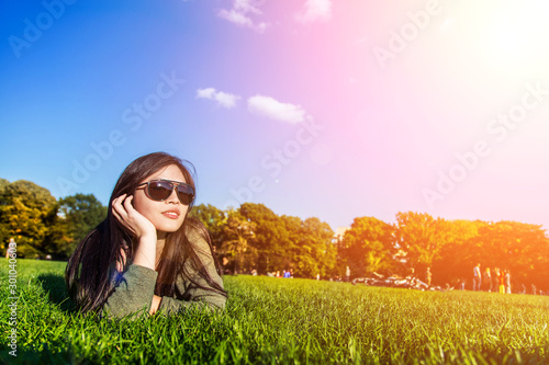 Happy woman wear sun glass relaxing on the grass  photo