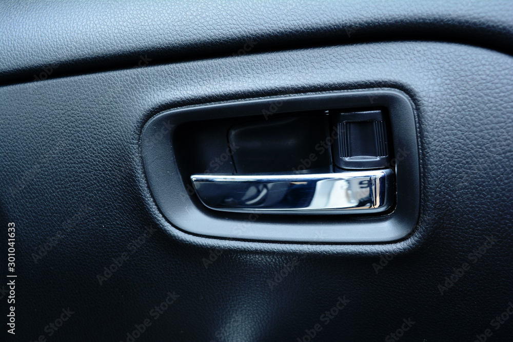 the hasp control  box of the left door on black leather panel in a car