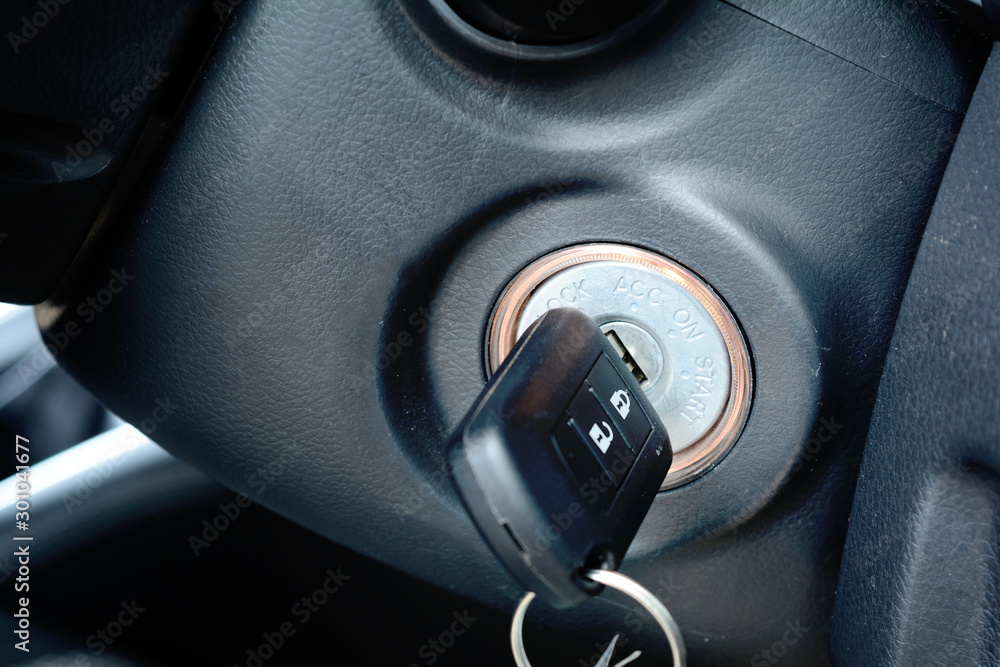 the black key with remote control inserted in a key slot at the circle panel that shown position to start , stop engine and electrical status of the car