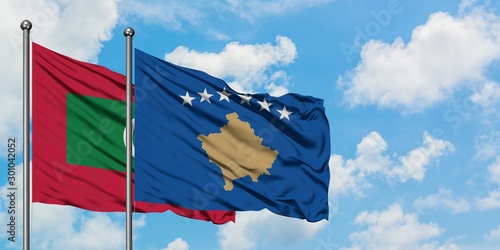 Maldives and Kosovo flag waving in the wind against white cloudy blue sky together. Diplomacy concept, international relations.