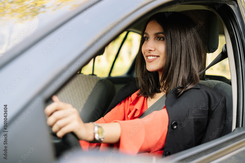 Brunette lady driving a car with safety belt
