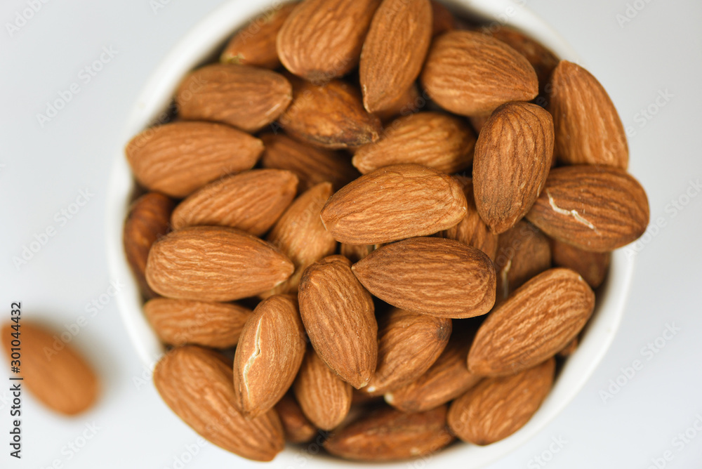 Almonds bowl isolated on gray background / Close up almond nuts natural protein food and for snack Almonds bowl isolated on gray background / Close up almond nuts natural protein food and for snack