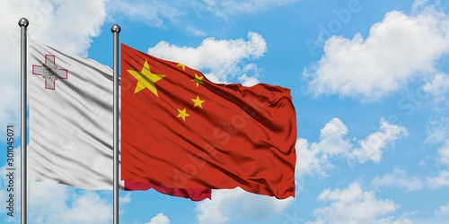 Bilde på lerret Malta and China flag waving in the wind against white cloudy blue sky together